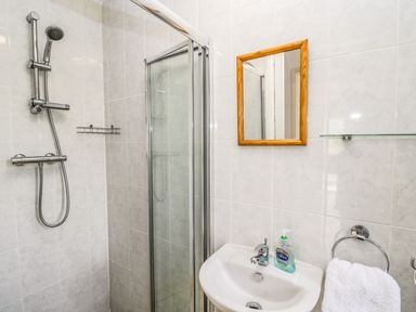 A bathroom with a shower enclosure sink mirror and towel at The Lodge in Dol-y-Gaer near Pontsticill