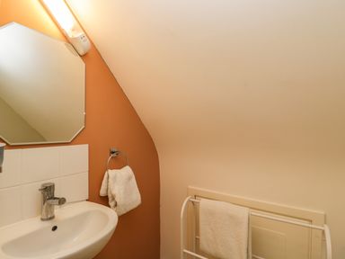 A bathroom sink with faucet mirror and towels on racks at The Lodge in Dol-y-Gaer near Pontsticill