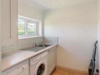 A laundry room with a washing machine a dishwasher a sink and a vacuum cleaner at Morlan Cottage in Newport Pembrokeshire