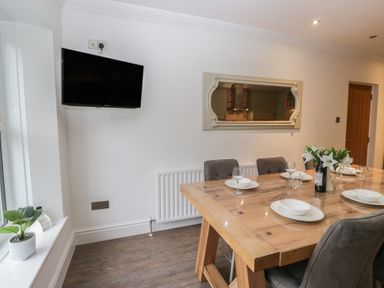 A dining room with a table and chairs at Chestnuts Cottage in Windermere