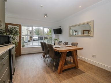 A dining room with a table and chairs at Chestnuts Cottage in Windermere