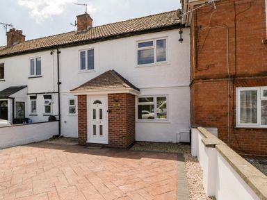 A front exterior view of a two-story terraced house with white walls and a small porch at Seacider in Burnham-On-Sea