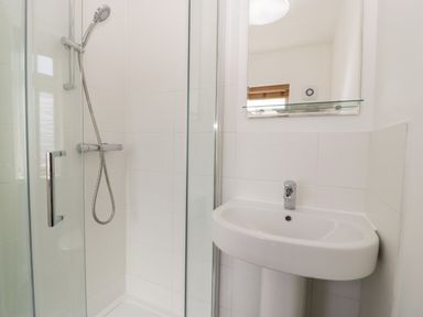 A bathroom with a glass shower enclosure and a wall-mounted sink at Seacider in Burnham-On-Sea