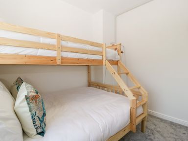A bedroom with a wooden bunk bed and pillows with marine designs at Seacider in Burnham-On-Sea