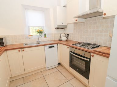 A kitchen with a sink dishwasher oven gas stove and microwave at Little Haven in Bamburgh