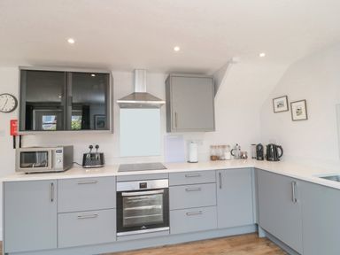 A kitchen with grey cabinets a microwave toaster oven and coffee maker at 3 St Cuthberts Garth Bamburgh