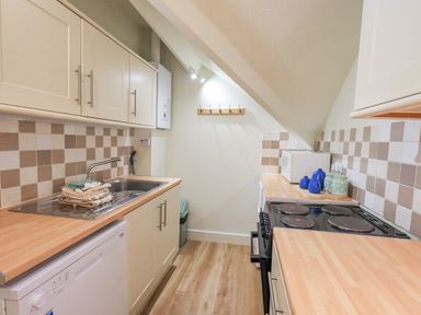 A kitchen with wood countertops a sink stove microwave and tiled backsplash at Windermere Crescent in Windermere