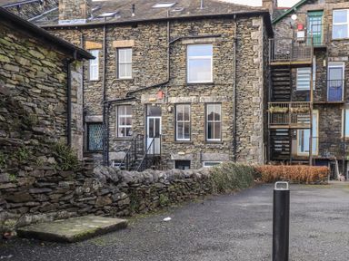 Stone buildings with multiple windows and metal staircases in an outdoor area at Windermere Crescent in Windermere