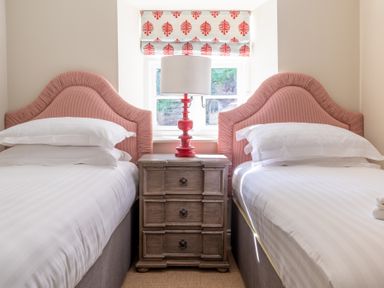 A bedroom with two single beds a wooden bedside table and a red lamp at Cunsey Mill House Cunsey near Hawkshead