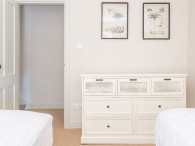 A bedroom with a white dresser between two beds and two framed pictures on the wall at Cunsey Mill House Cunsey near Hawkshead
