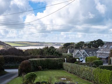 A garden and hedges with houses and fields in the background at Croft Elms in Trebetherick near Polzeath