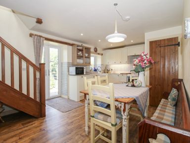 A kitchen with a dining table and a staircase at Buzzards Breg in Builth Wells