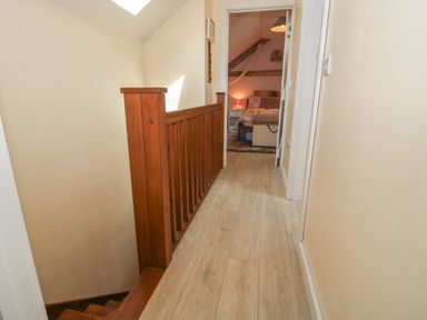 A hallway with wooden railing and doors at Buzzards Breg in Builth Wells