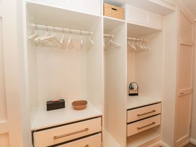 A wardrobe with hangers drawers a small mirror and storage baskets at The Treeline in Swarland near Felton