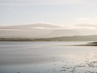 A coastal landscape with calm water and distant hills at The Beachhouse in Meenlaragh near Gortahork County Donegal