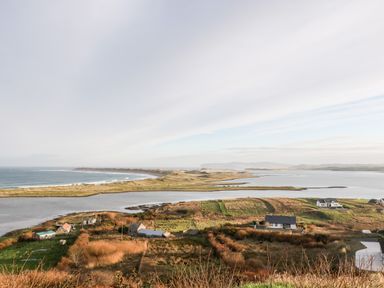 A coastal landscape with houses farmland water and hills at The Beachhouse in Meenlaragh near Gortahork County Donegal