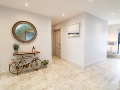 A hallway with a mirror above a bicycle-shaped console table and plants at The Beachhouse in Meenlaragh near Gortahork County Donegal