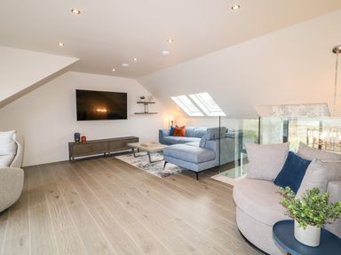 A living room with sofas a wall mounted television and skylight windows at The Beachhouse in Meenlaragh near Gortahork County Donegal