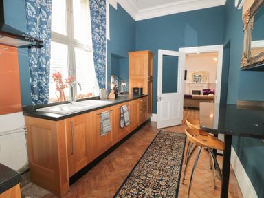 A kitchen with wooden cabinets a sink and counter stools at The Vault House in Bellingham