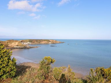 A coastal view with a small bay ocean and vegetation at Min Y Mor - Morfa Nefyn