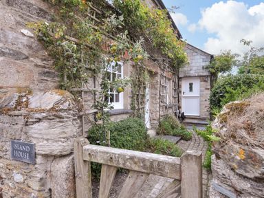 An entrance with a stone wall and gate at Island House in Golant near Tywardreath