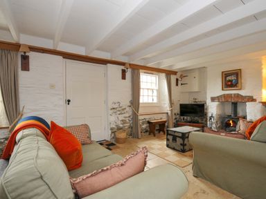 A living room with a sofa and fireplace at Island House in Golant near Tywardreath