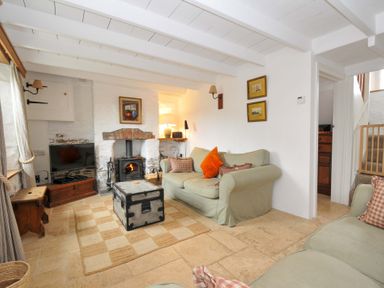 A living room with a sofa, fireplace, and coffee table at Island House in Golant near Tywardreath