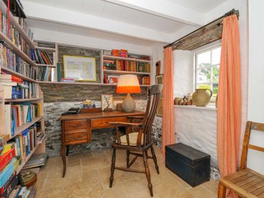 A study with a desk, bookshelf, and window at Island House Golant near Tywardreath