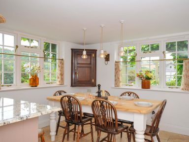 A kitchen with a dining table and chairs at Island House in Golant near Tywardreath