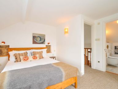 A bedroom with a bed and artwork at Island House in Golant near Tywardreath