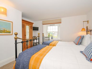A bedroom with two beds and a wardrobe at Island House in Golant near Tywardreath