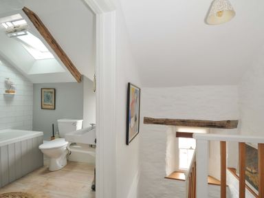 A bathroom with a bathtub and toilet at Island House Golant near Tywardreath