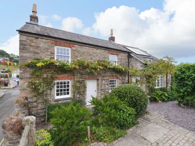 A stone cottage with a garden and pathway at Island House in Golant near Tywardreath