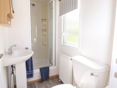 A bathroom with a shower cubicle sink and toilet at The Maples in Steel Green near Haverigg