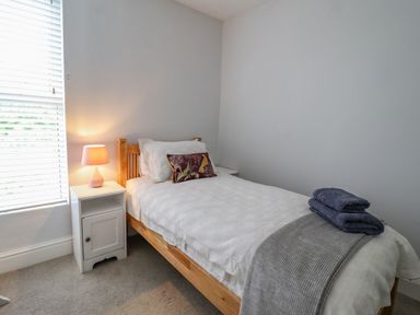 A bedroom with a single bed bedside tables and a lamp at 24 Cadnant Park in Conwy