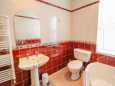 A bathroom with a sink toilet bathtub and window at 24 Cadnant Park in Conwy
