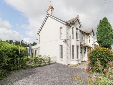 An exterior view of a semi detached house with a gravel driveway and garden at 24 Cadnant Park Conwy
