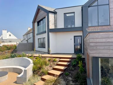 Exterior view of a modern two story house with stairs and garden at The Old Coastguard Lookout in Port Isaac