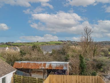 A rural landscape with an old corrugated metal shed trees and green fields at Shrimper's Cottage in Tredrizzick near St Minver