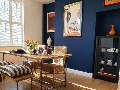 A dining room with a wooden table set for breakfast and wicker chairs at No.37 in Beverley