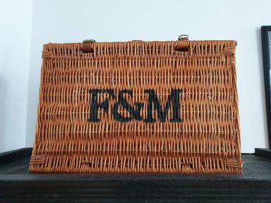 A wicker basket with the letters F M on it placed against a white wall at No.37 in Beverley