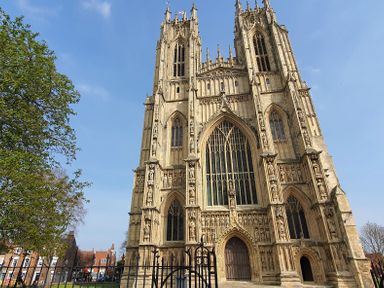 A large gothic cathedral with detailed stone carvings and tall spires under a clear sky at No.37 in Beverley