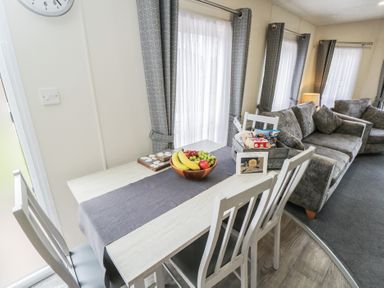 A dining area with a table and fruit at The Cotswold Holiday Lodge in Evesham