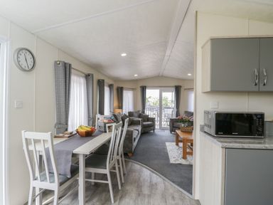 A living room with furniture and dining area at The Cotswold Holiday Lodge in Evesham