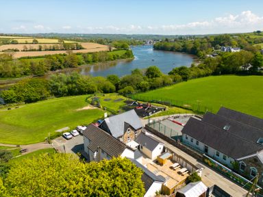 A view of a river with fields trees a playground and buildings at Teifi Villa in St Dogmaels