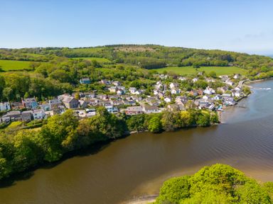 A riverside village with houses and trees near green fields at Teifi Villa in St Dogmaels