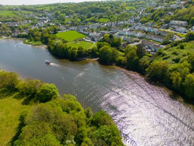 A river flowing through a town with houses and trees along the banks at Teifi Villa in St Dogmaels