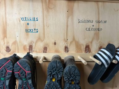 An entryway shoe rack with wellies and boots at Teifi Villa St Dogmaels