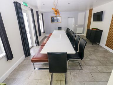 A dining room with a large table and chairs at Teifi Villa in St Dogmaels