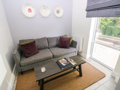 A snug area with a couch and coffee table at Teifi Villa St Dogmaels